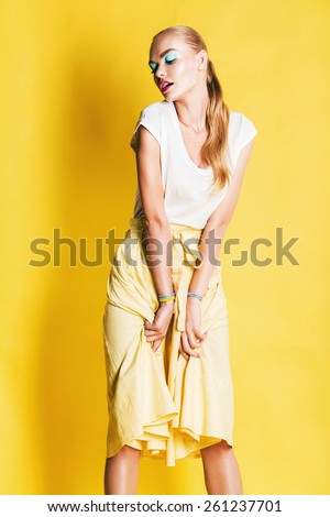 sexy woman in yellow skirt with pink lips on yellow background