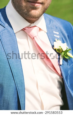 close up portrait of groom suit at sunny day