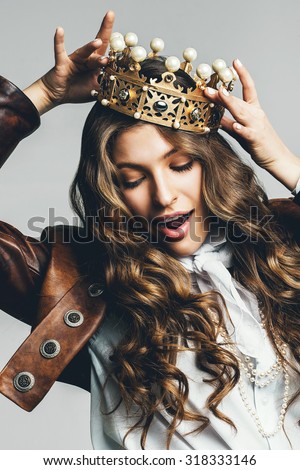 dynamic woman in brown leather jacket with golden crown