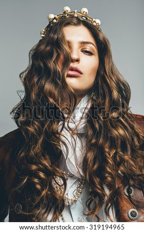 beautiful sexy woman with long curly hair in crown in leather jacket