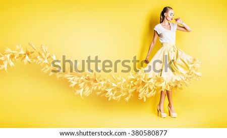sexy dancing woman in flowing yellow skirt on yellow background