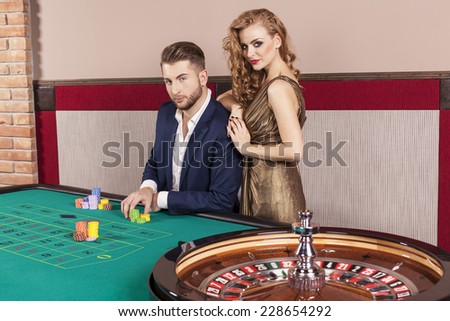 Man and woman by the roulette table at casino