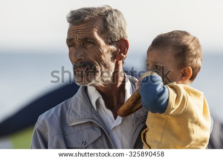 Kos, Greece - October 10, 2015: Syrian man with a child in volunteers aid point