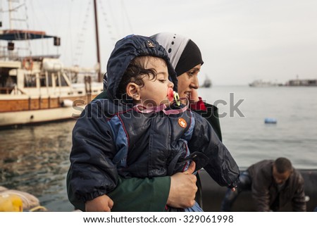 Kos, Greece - October 17, 2015: Woman is carrying a baby in the port of Kos town on the Kos island, Greece.