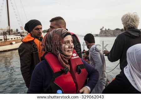 Kos, Greece - October 17, 2015: Woman dressed in lifejacket has just left dinghy boat on which she came from Turkey to the port of Kos town on Kos island, Greece.