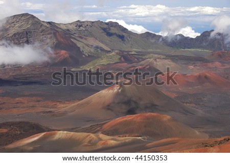 The crater of a volcano.Red dirt rocks and a blue sky form this amazing moon like landscape of this volcano top, above the clouds. Haleakala National Park in Maui, Hawaii.