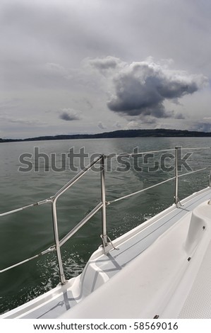 View of seascape  from the deck of a sailboat. Grey storm and green sea.