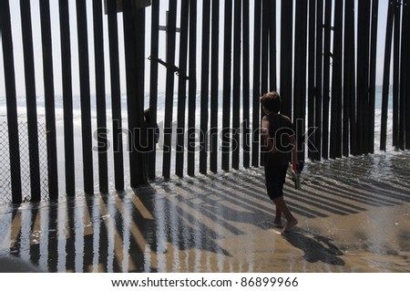 American kid meets mexican kid on the other side of the fence. USA Mexico Border, San Diego Tijuana.