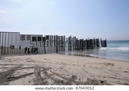 SAN DIEGO, CA- OCTOBER 16: Unidentified people stand at the end of the border between USA and Mexico on Oct. 16, 2011 in San Diego, CA. They are in Tijuana, Mexico, separated by a fence that goes into the Pacific Ocean.