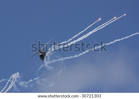 A Navy SH-60B helicopter shooting flares during a military exercise in 2008 with the smoke trails disrupted by rotor wash (http://www.artistovision.com/military/helicopter-shooting-flares.html).