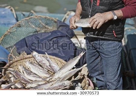 A local fisherman at the Lantau fishing village near Hong Kong shows off his recent catch to passers by (http://www.artistovision.com/hongkong/man-with-fish-basket.html).