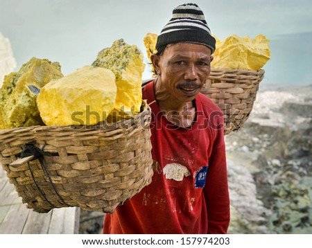 KAWAH IJEN VOLCANO, EAST JAVA, INDONESIA - MAY 25, 2013: Portrait of a sulfur miner carrying baskets loaded with sulfur inside the crater of Kawah Ijen volcano in East Java, Indonesia.