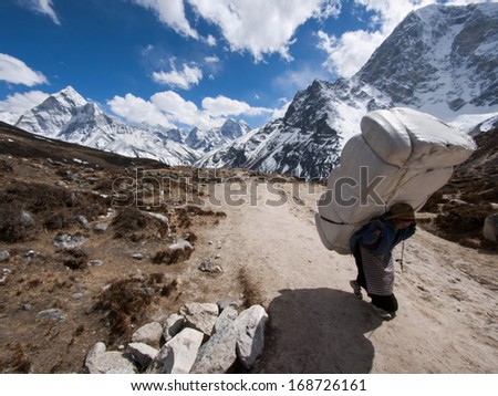 Everest Region, Nepal - March 23, 2013: A Sherpa Porter Carries A Large Load Uphill Near The Himalayan Settlement Of Lobuche Along The Everest Base Camp Trek In Nepal.