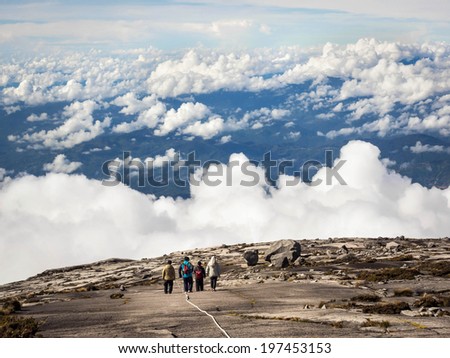 Hikers walking above the clouds at the top of Mount Kinabalu in Sabah, East Malaysia.