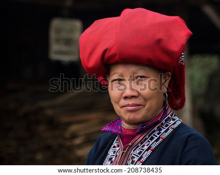 Woman from Red Dao minority group wearing traditional attire and headdress in Sapa, Lao Cai Province, Vietnam.