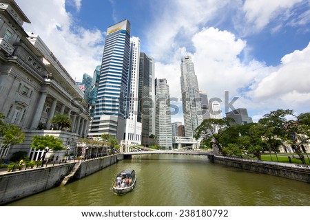 Singapore City, Singapore - June 1, 2014: View of tourist boat floating on Singapore river with downtown buildings in the background on June 1, 2014, in Singapore City, Singapore.