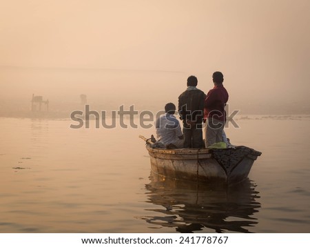 Hindu pilgrims approaching the East bank of the Ganges river by boat in Varanasi, Uttar Pradesh, India.
