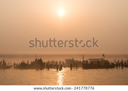 Hindu pilgrims bathing on the East bank of the Ganges river at sunrise in Varanasi, Uttar Pradesh, India.