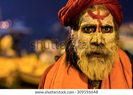 Varanasi, India - February 14: Indian sadhu covered in ash and wearing traditional attire by the sacred Ganges river in Varanasi, Uttar Pradesh, India.