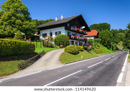 Rural road and traditional alpine house near Attersee lake, Austria