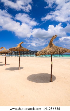 Row line sun shade umbrella beach white sand sea white clouds blue sky, Alcudia, Majorca island, Spain