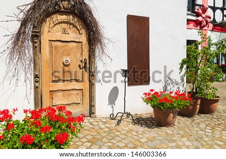 Wooden door white wall house red flowers pot, Rowy town seaside destination, Baltic Sea, Poland