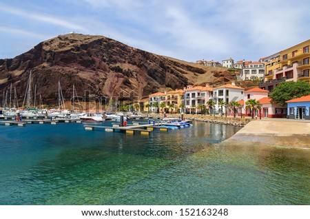 Port with boats and yachts and colorful houses with mountain view, Madeira island, Portugal
