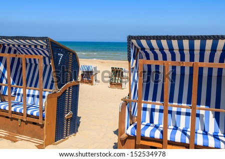 White and blue beach chairs on sand with sea view on hot summer day, Ustka, Baltic Sea, Poland