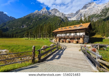 Wooden bridge stable building in the background and green pasture mountain valley, Fischleintal, Val Fiscalina Pustertal, Sudtirol, Italy