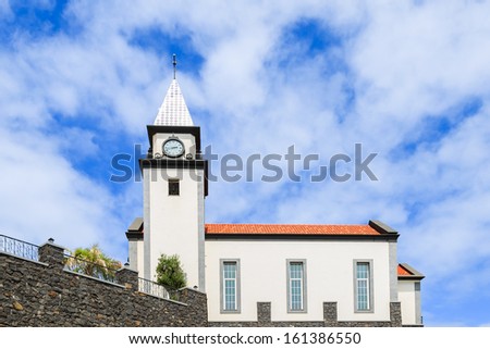 White church building in small Portuguese town with sunny sky and white clouds, Madeira island, Portugal