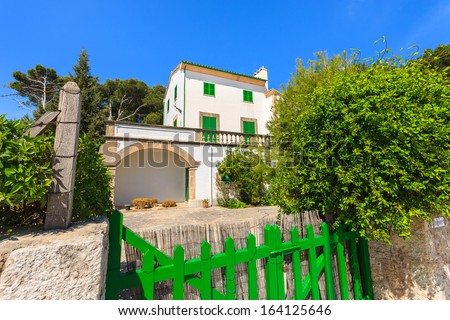 Traditional holiday villa and green fence gate in Port Pollenca town on Majorca island, Spain