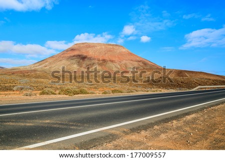 Road to Corralejo with red lava volcano mountain view, Fuerteventura, Canary Islands, Spain
