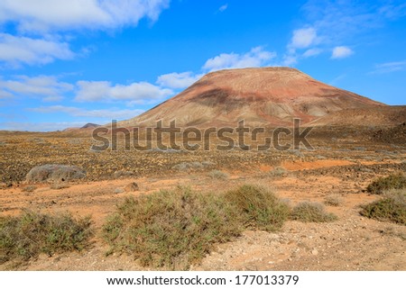 Red volcano mountain near Corralejo National Park, Fuerteventura, Canary Islands, Spain