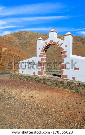 Traditional white gate built of lava stones indicating commune border of Tuineje town, Fuerteventura, Canary Islands, Spain