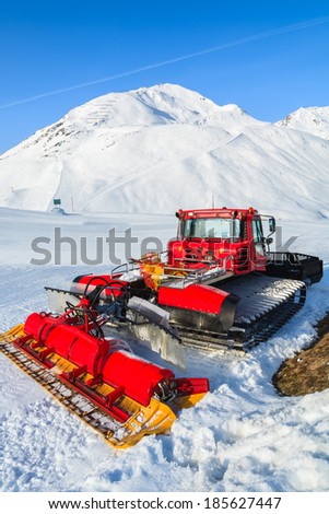 RIFFELSEE SKI RESORT, AUSTRIA - MAR 30: Red snow groomer on ski slope in Riffelsee mountain resort on 30th Mar 2014, Austrian Alps