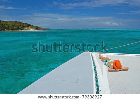 Woman relaxing on catamaran near Tobago Cays on Caribbean Sea