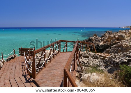 Wooden jetty leading to beautiful sea water of Konnos Bay on Cyprus island