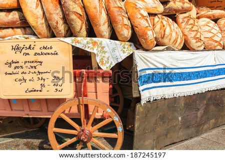 Bread loafs on wooden cart during Easter fair on main market square of Krakow (sale label: traditional bread made on sourdough that can be eaten for 2 weeks) , Poland