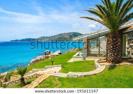 Beautiful holiday villa house on coast of Sardinia island - view from promenade at Campolungo beach, Italy