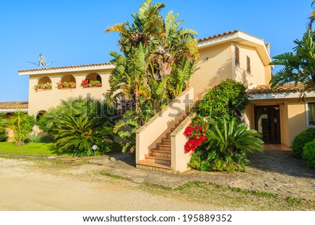 PORTO GIUNCO, SARDINIA - MAY 24, 2014: holiday apartment hotel in tropical gardens, Sardinia island, Italy. Southern part of the island is popular for beach vacation among Europeans.
