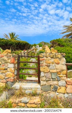 Wooden gate to holiday house on coast of Sardinia island near Spiaggia del Riso beach, Italy
