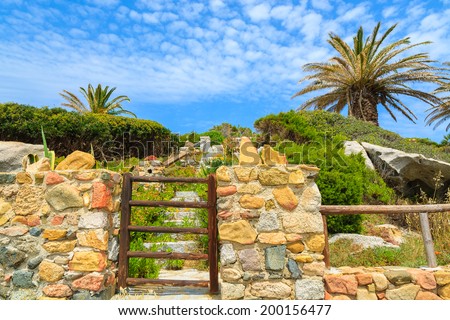 Wooden gate to holiday house on coast of Sardinia island near Spiaggia del Riso beach, Italy