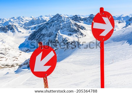 Red signs on ski slope in ski resort of Pitztal, Austrian Alps