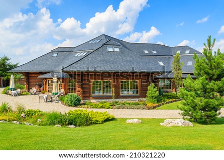 VILLAGE NEAR KRAKOW, POLAND - AUG 9, 2014:green garden of traditional restaurant building on sunny summer day. Mountain style architecture is very popular in south of Poland.