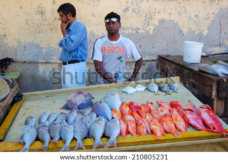 GRAND BAIE, MAURITIUS ISLAND - SEP 25, 2010: local men sell fish on roadside stall in Grand Baie coastal town. Many people in this are make a living on sea fishing.