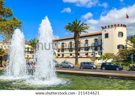 FUNCHAL, MADEIRA - AUG 25, 2013: Main street of Funchal historic old town with palm tree and water fountain. Funchal is main holiday resort on this Portuguese island.