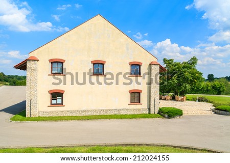 Street with historic restaurant building with chairs and tables on sunny terrace in Paczultowice village, Poland