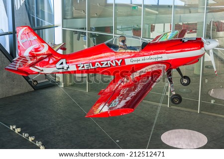 KRAKOW MUSEUM OF AVIATION, POLAND - JUL 27, 2014: red acrobatic plane hanging on exhibition in indoor museum of aviation history in Krakow, Poland. In summer often airshows take place here.