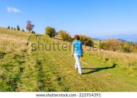 Young woman tourist walking on mountain path in Pieniny Mountains on sunny autumn day, Poland