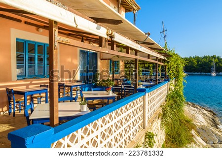 Blue chairs with tables in traditional Greek tavern in Fiskardo port, Kefalonia island, Greece